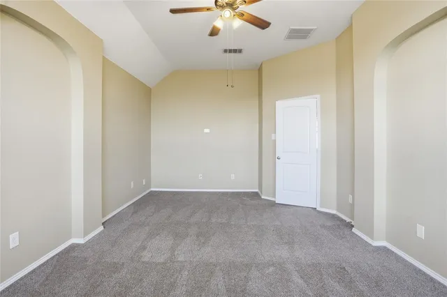 an empty room with a ceiling fan and carpet