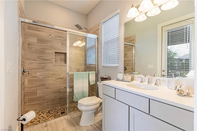 a bathroom with a sink a toilet and shower