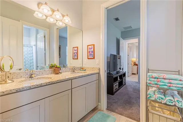 a en suite bathroom with a sink double vanity and a mirror