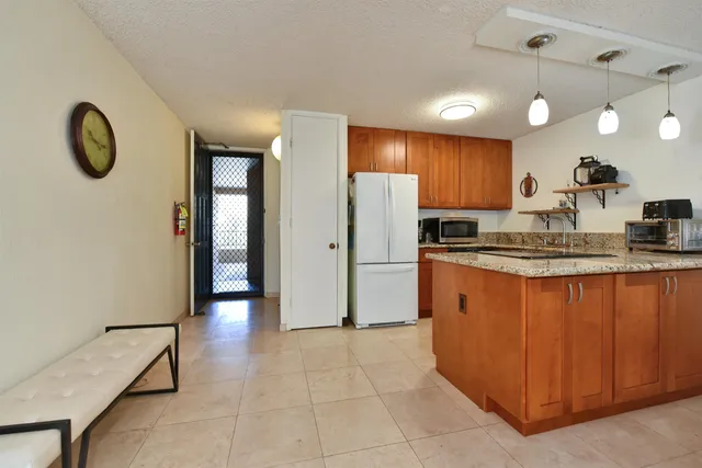a kitchen with stainless steel appliances granite countertop a refrigerator and a sink