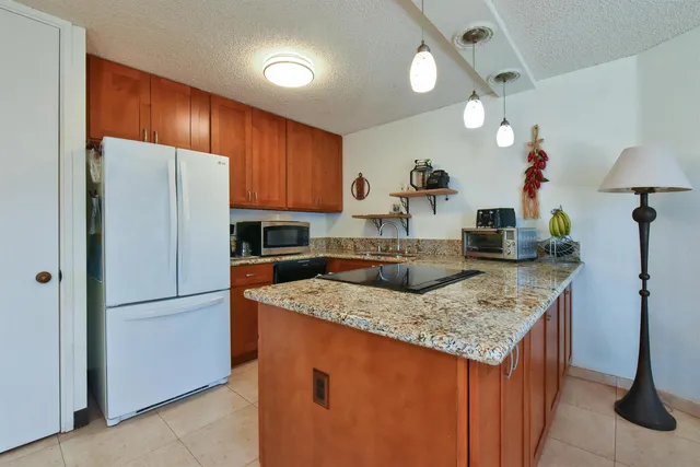 a kitchen with stainless steel appliances granite countertop sink refrigerator and microwave
