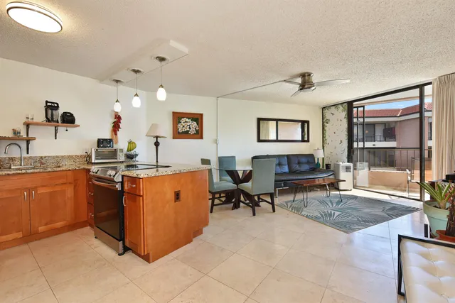 a living room with granite countertop furniture and a kitchen view