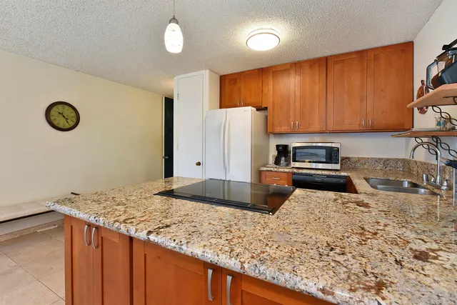 a kitchen with stainless steel appliances granite countertop a sink refrigerator stove and microwave