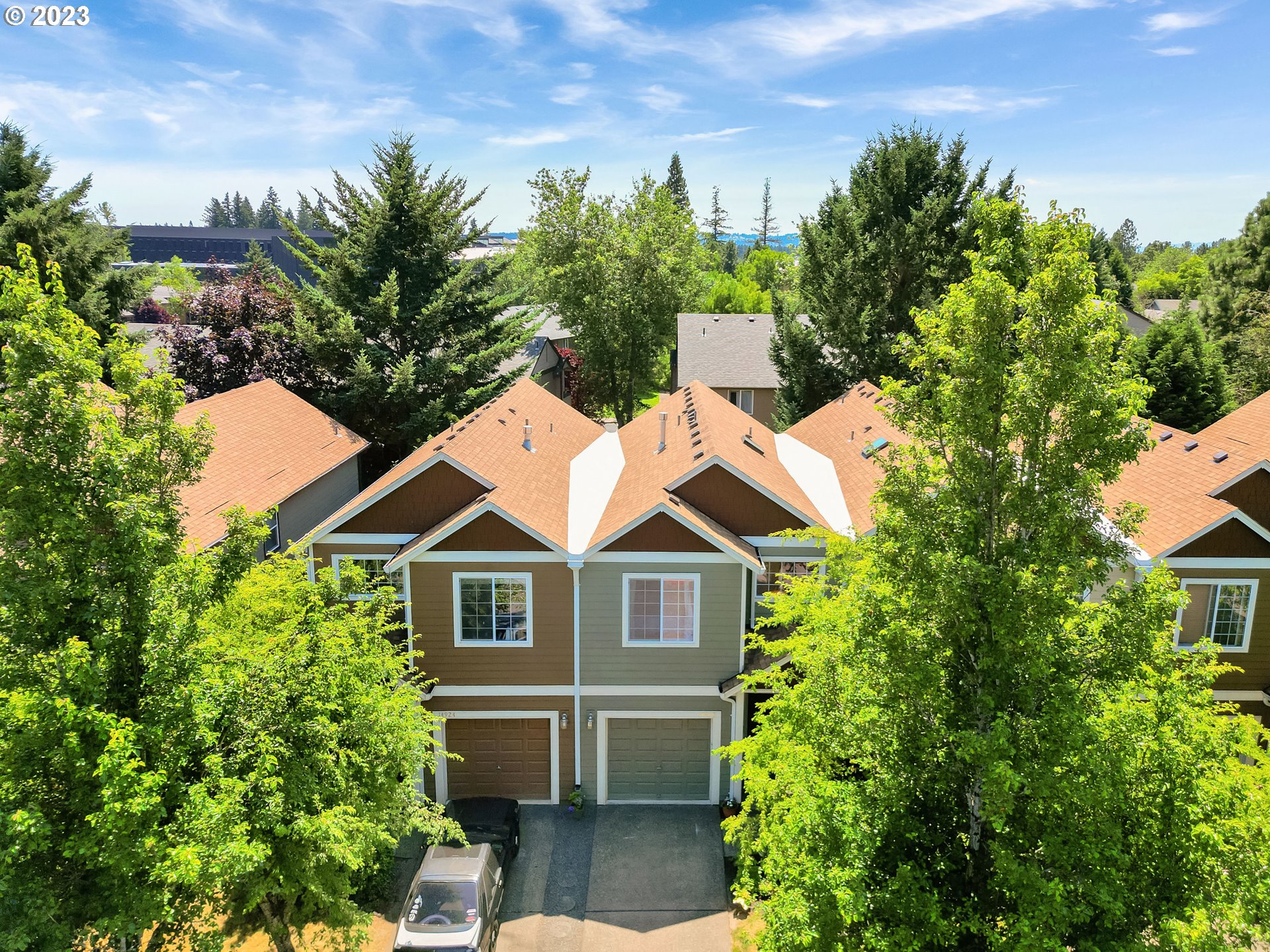 14930 Southwest Conor Circle Beaverton, OR 97006 - Photo 28 of 29 a view of a brick house with a large windows and a yard with plants and large trees