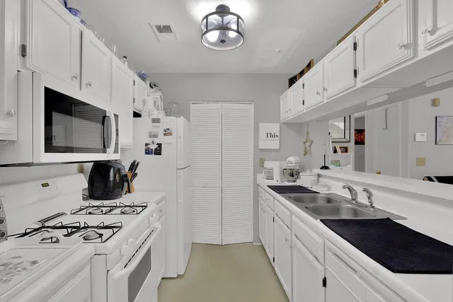 a kitchen with stainless steel appliances a stove a sink and a microwave