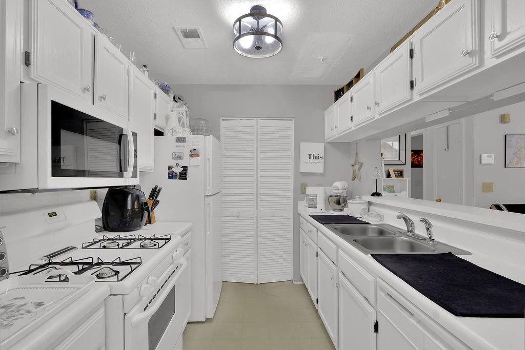a kitchen with stainless steel appliances a stove a sink and a microwave