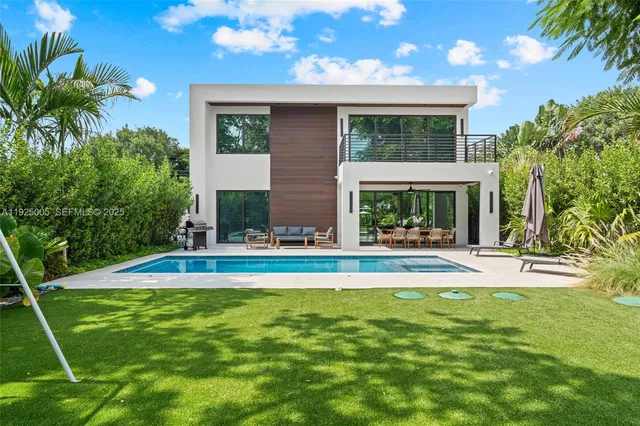 a view of swimming pool with lawn chairs and plants