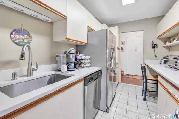 a kitchen with stainless steel appliances granite countertop a sink and a refrigerator
