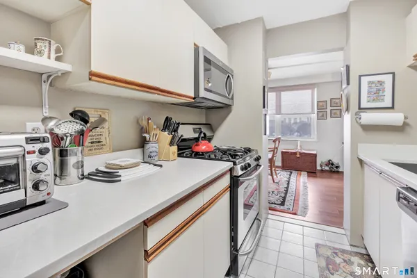 a kitchen with kitchen island a stove a sink and cabinets