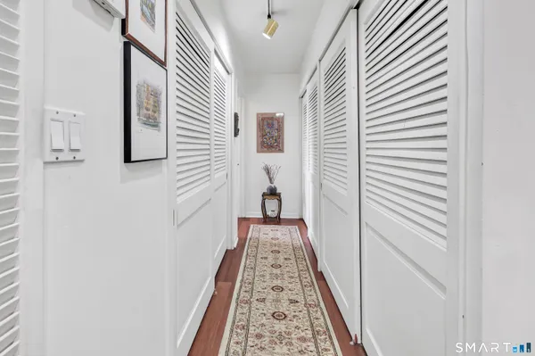 a view of a hallway with wooden floor and staircase