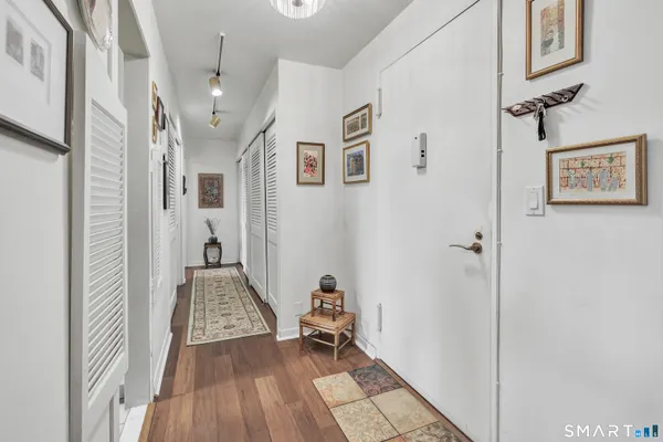a view of a hallway with wooden floor and a livingroom
