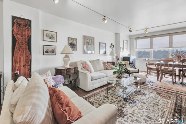 a living room with furniture large window and glass table