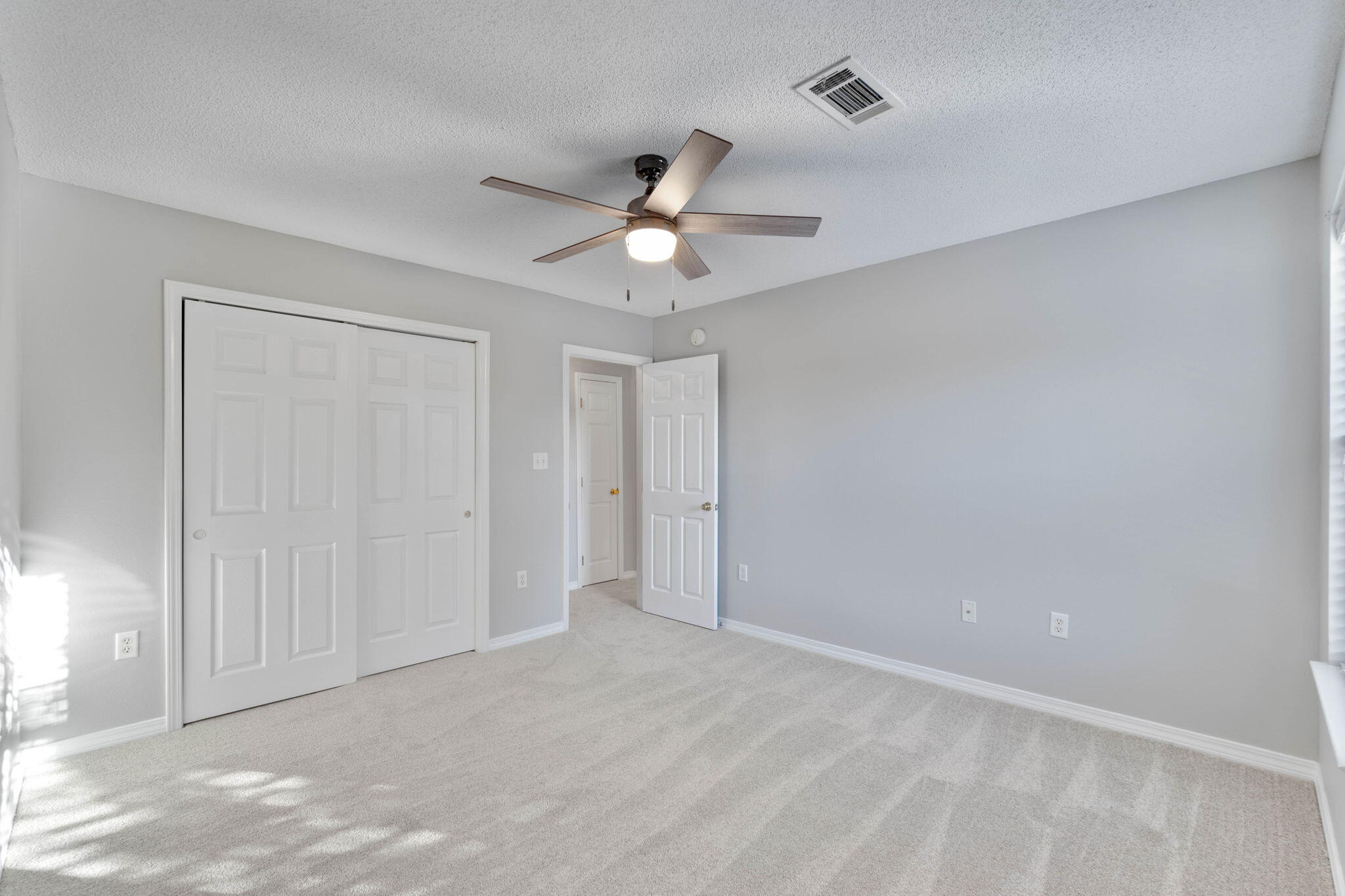 2145 Tom Street Navarre, FL 32566 - Photo 15 of 22 a view of an empty room and a ceiling fan & windows