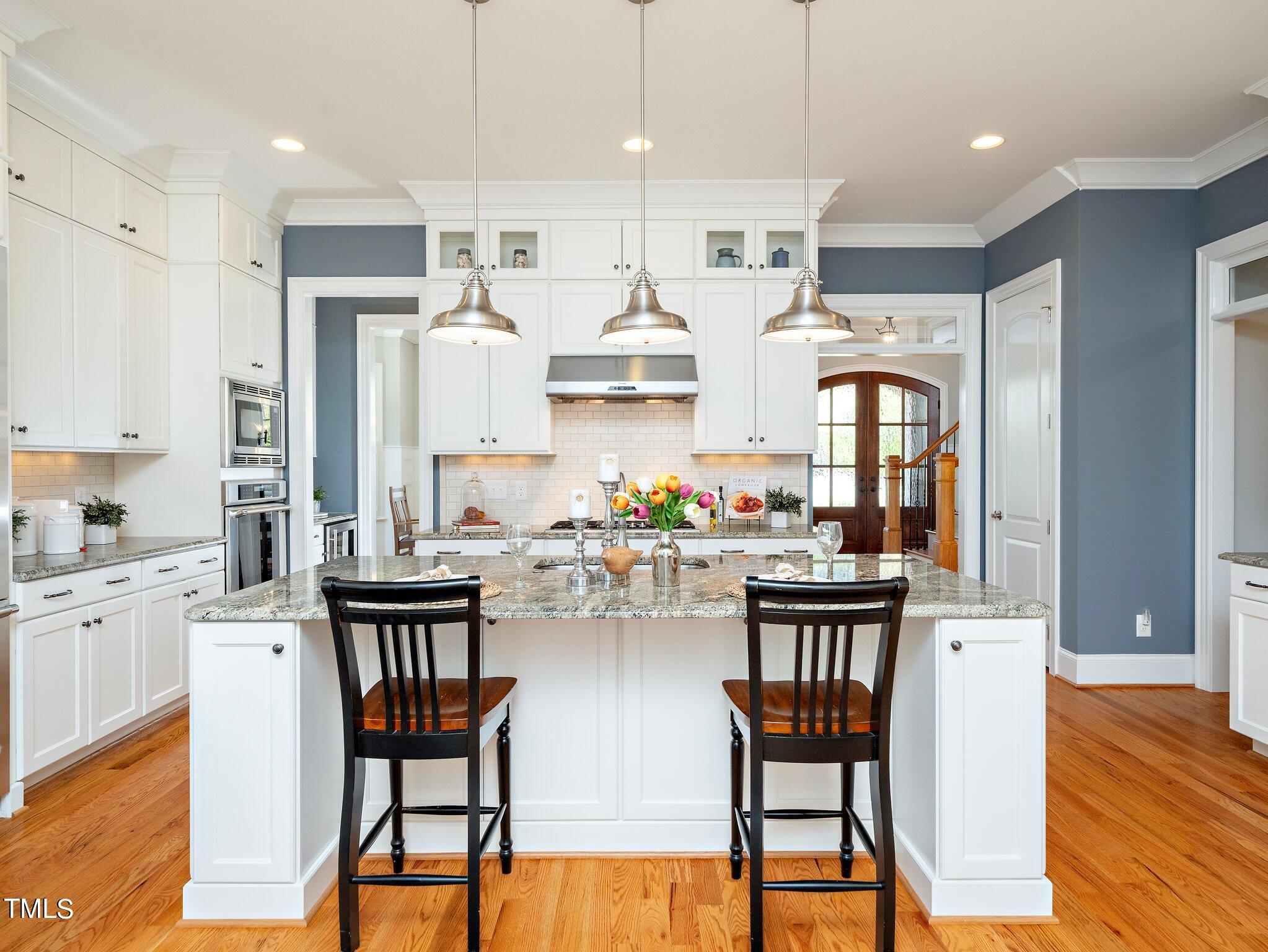 3311 Churchill Road Raleigh, NC 27607 - Photo 2 of 15 a kitchen with stainless steel appliances kitchen island granite countertop a table chairs and a refrigerator