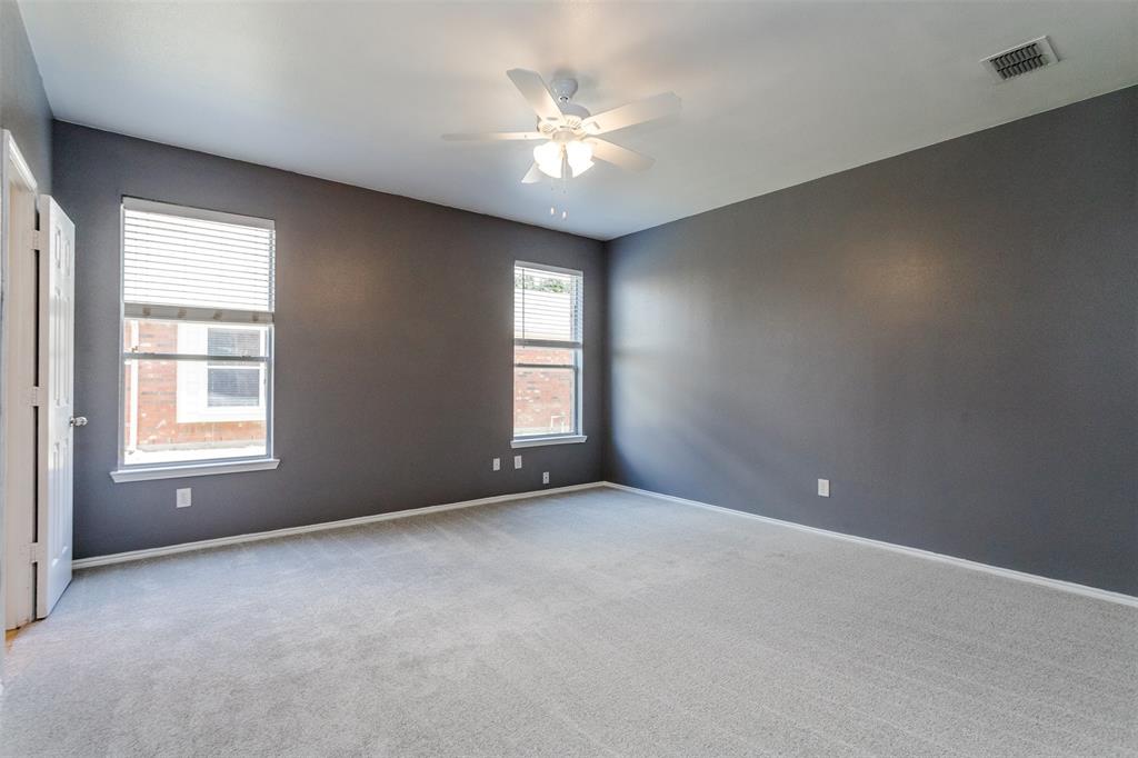 203 Arabian Road Waxahachie, TX 75165 - Photo 12 of 24 Spacious room featuring neutral carpeting, two windows with blinds, a ceiling fan with integrated lighting, and a white paneled door