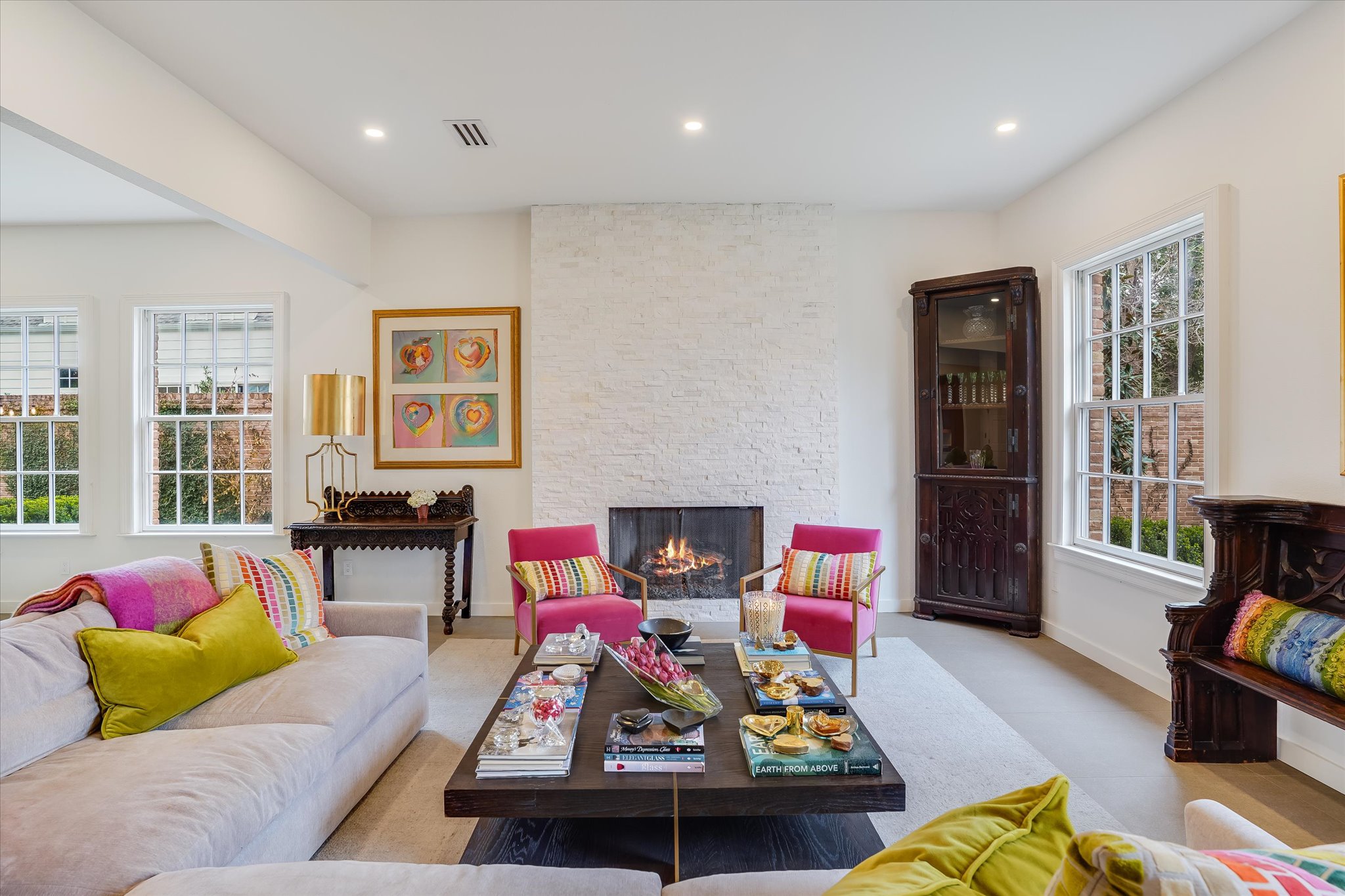 Living area with recessed lighting, plenty of natural light, and a stone fireplace