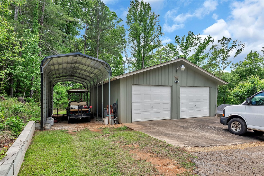 110 Lakeshore Lane Seneca, SC 29678 - Photo 39 of 50 This property features a practical garage and an additional carport, ideal for diverse vehicle storage needs.