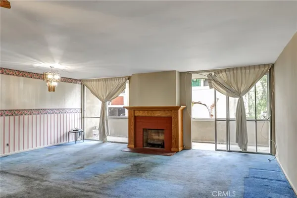 a view of an empty room with a fireplace and a window