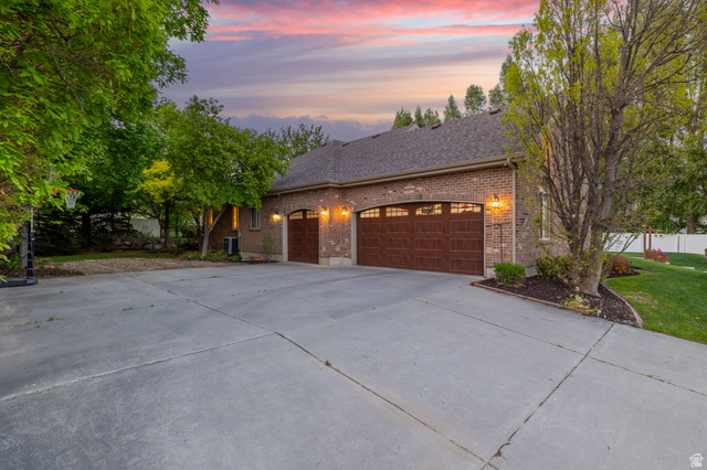 6208 West Bull River Road Highland, UT 84003 - Photo 80 of 90 Brick exterior featuring two arched garage doors with windows
