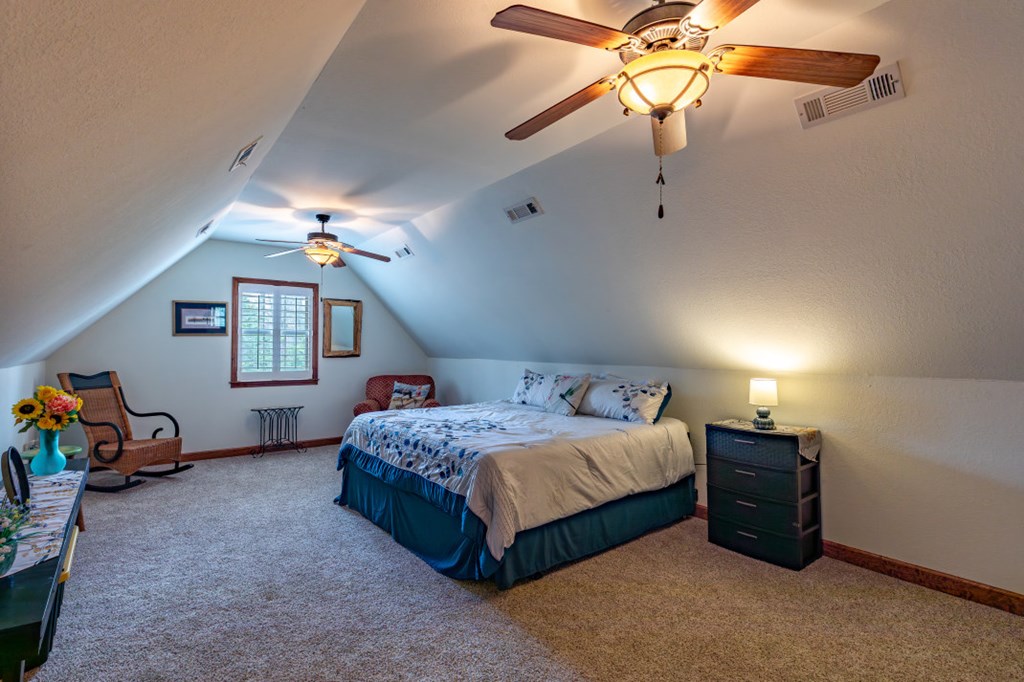 159 Apple Blossom Road Blairsville, GA 30512 - Photo 23 of 56 a bedroom with a bed a chandelier and a dresser