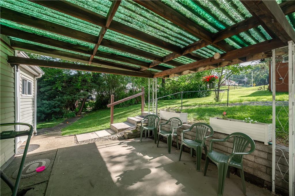 411 Harmony Road Baden, PA 15005 - Photo 23 of 25 a view of a patio with table and chairs potted plants with wooden floor and fence