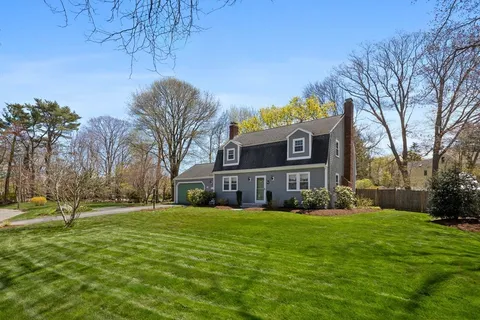 a front view of building with yard and trees