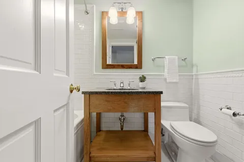 a bathroom with a toilet sink and mirror