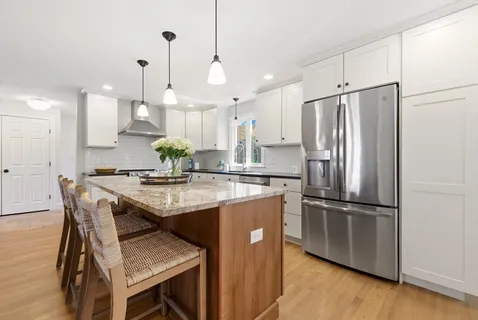 a kitchen with stainless steel appliances granite countertop a sink a refrigerator and a refrigerator
