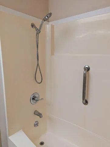 a bathroom with a bath tub with a shower