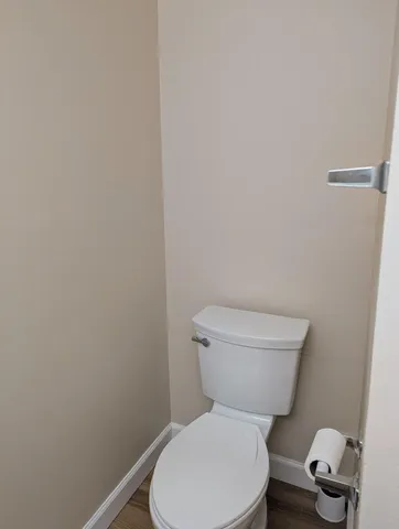 a white toilet sitting next to a white wall