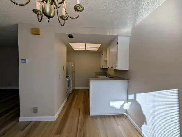 a kitchen with a refrigerator and wooden floor