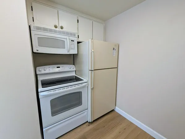a kitchen with a stove a refrigerator and a microwave