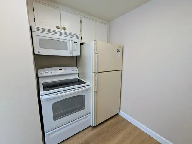 a kitchen with a stove a refrigerator and a microwave