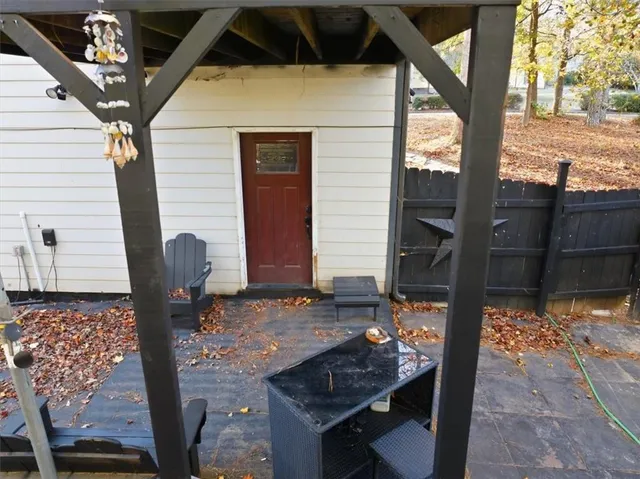 a balcony with table and chairs with wooden floor and fence