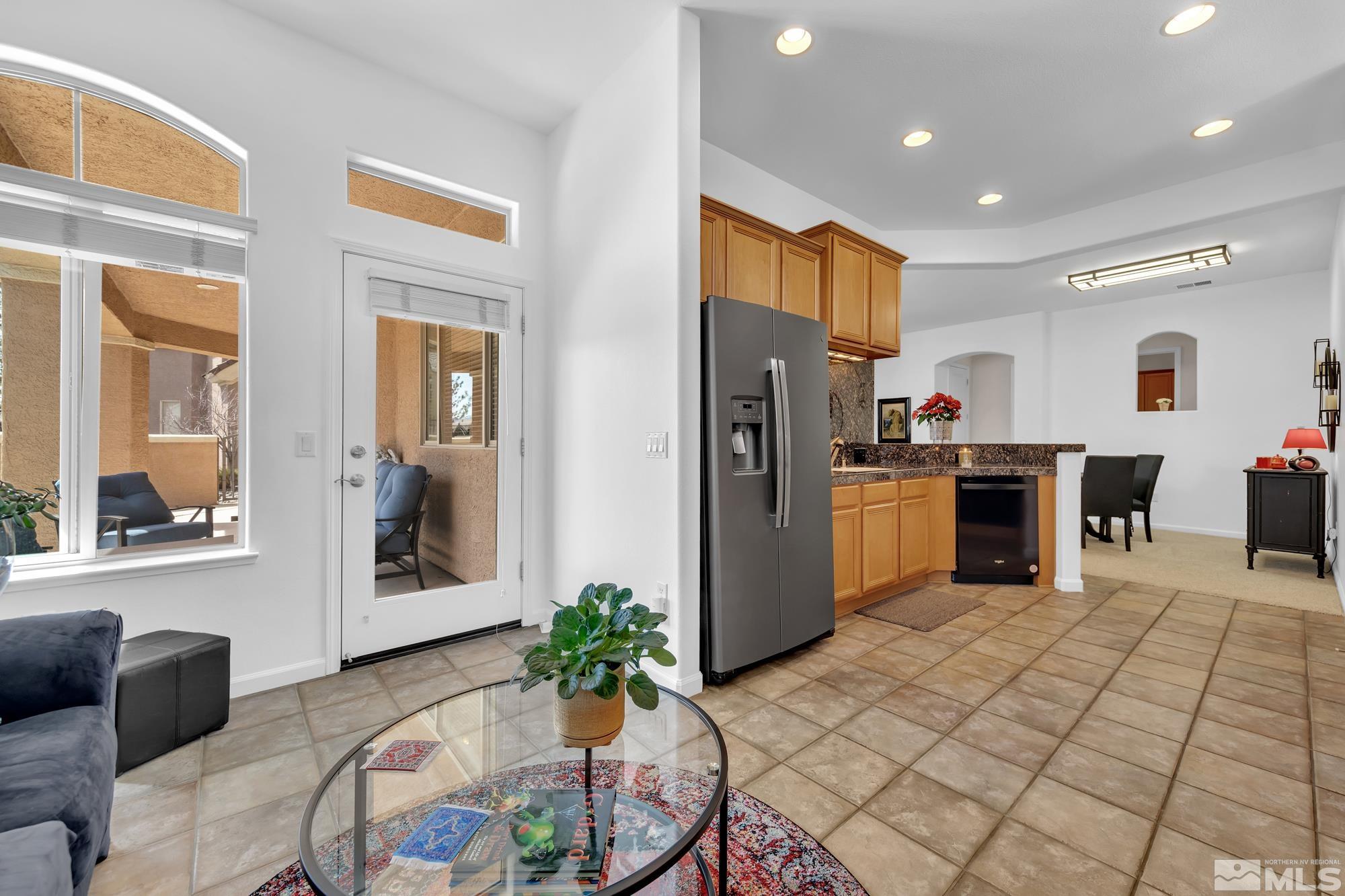 9900 Wilbur May, Unit 3902 Reno, NV 89521 - Photo 12 of 28 a kitchen with stainless steel appliances kitchen island granite countertop a refrigerator and a stove top oven
