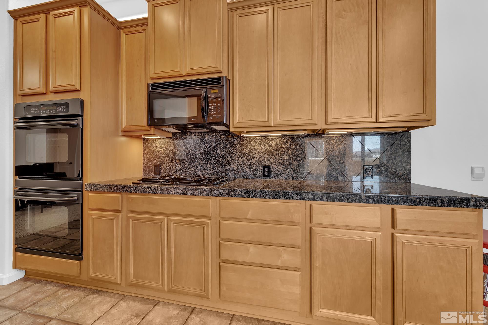 9900 Wilbur May, Unit 3902 Reno, NV 89521 - Photo 18 of 28 a kitchen with stainless steel appliances granite countertop a stove a sink and a microwave
