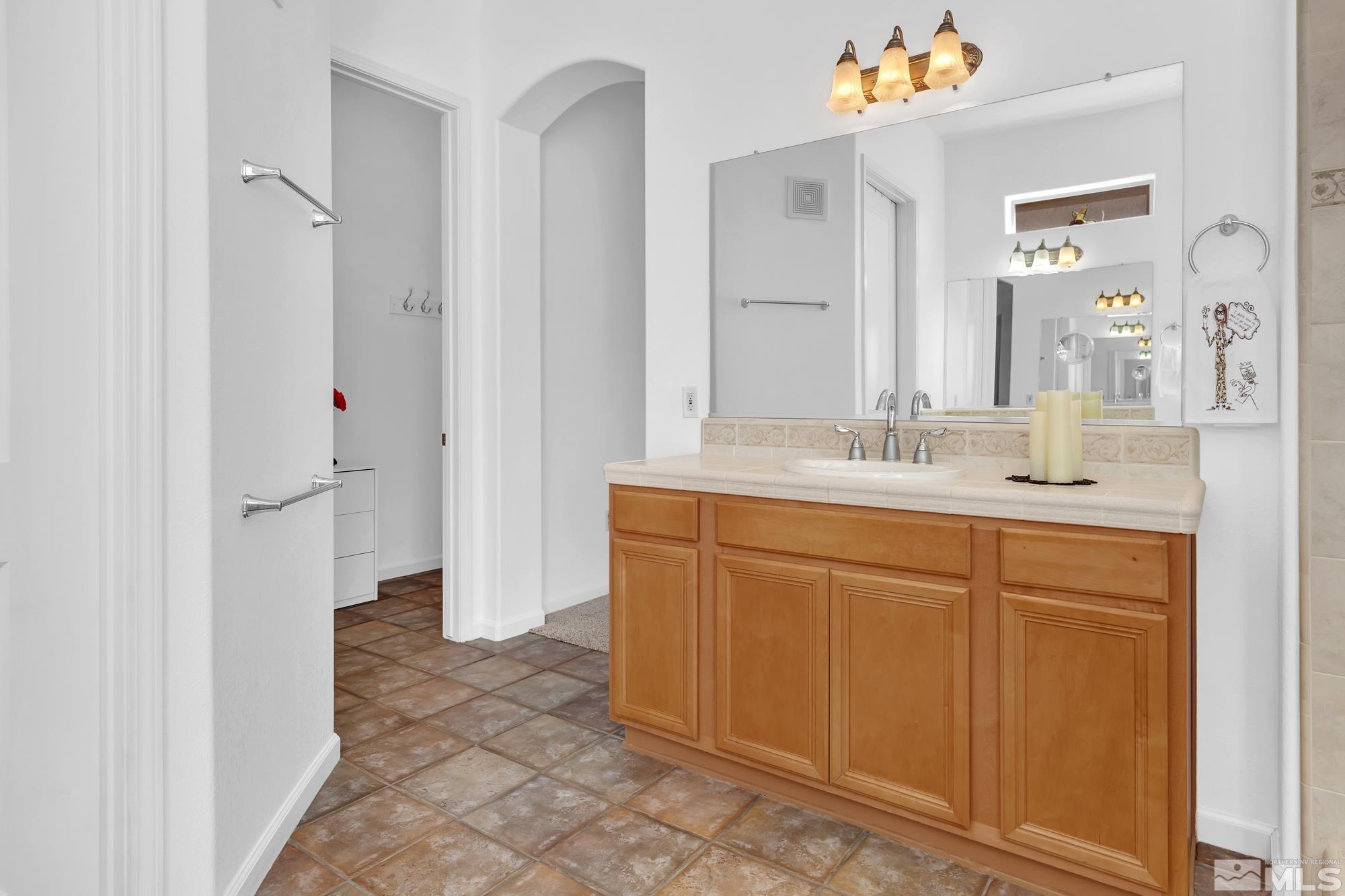 9900 Wilbur May, Unit 3902 Reno, NV 89521 - Photo 24 of 28 a bathroom with a sink vanity and a mirror