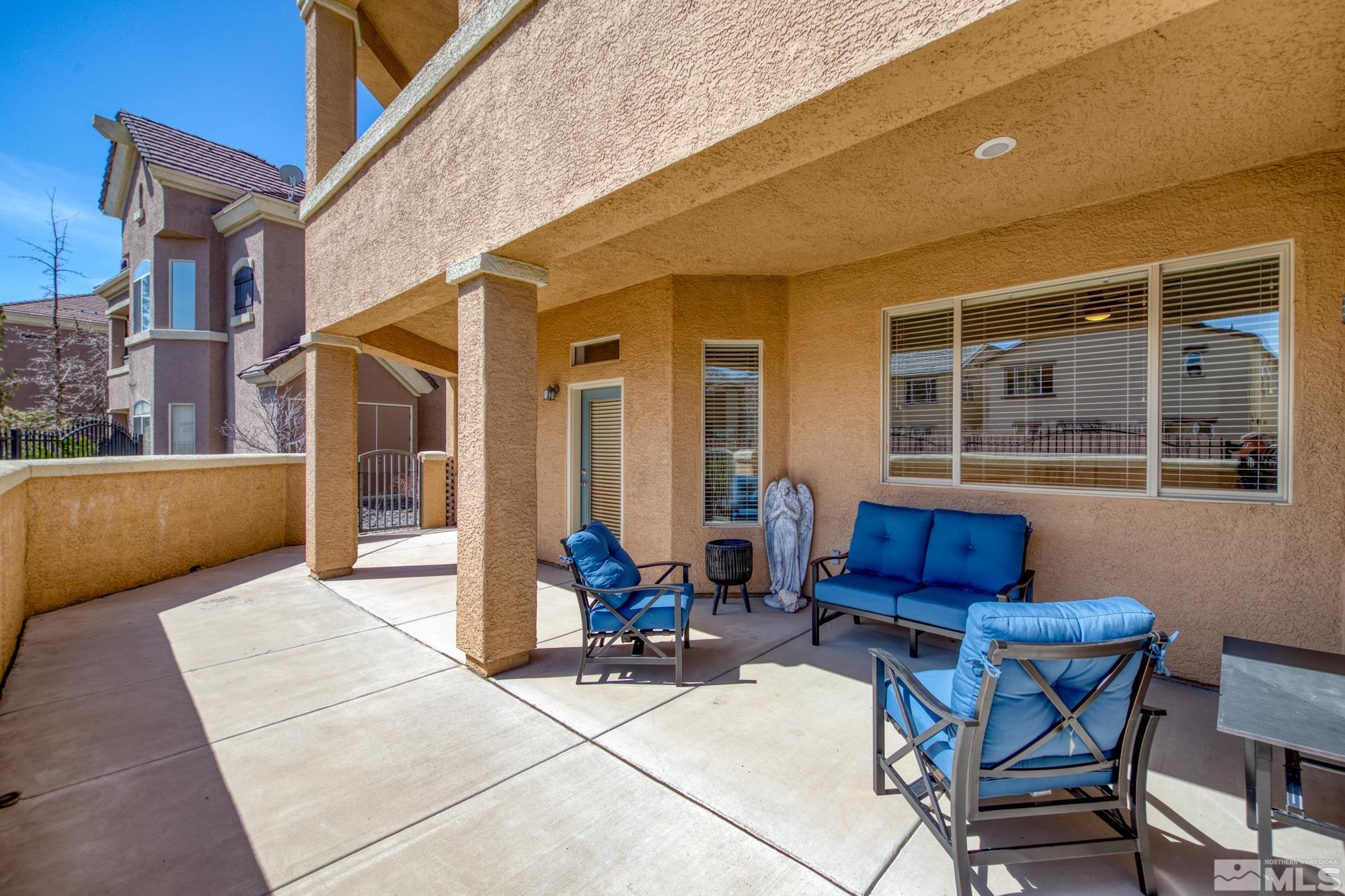 9900 Wilbur May, Unit 3902 Reno, NV 89521 - Photo 3 of 28 a view of a patio with table and chairs and wooden fence
