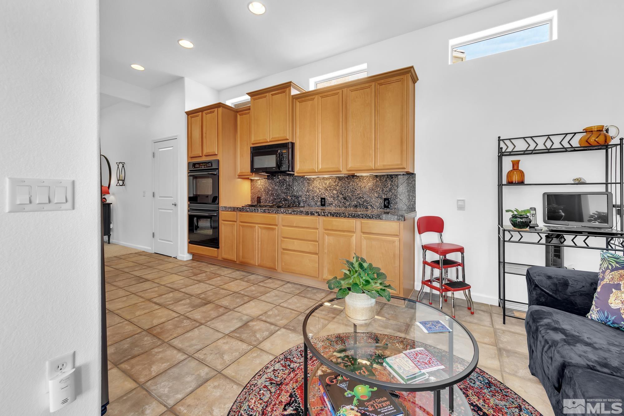 9900 Wilbur May, Unit 3902 Reno, NV 89521 - Photo 7 of 28 a kitchen with stainless steel appliances kitchen island granite countertop a refrigerator a sink a stove with wooden floor