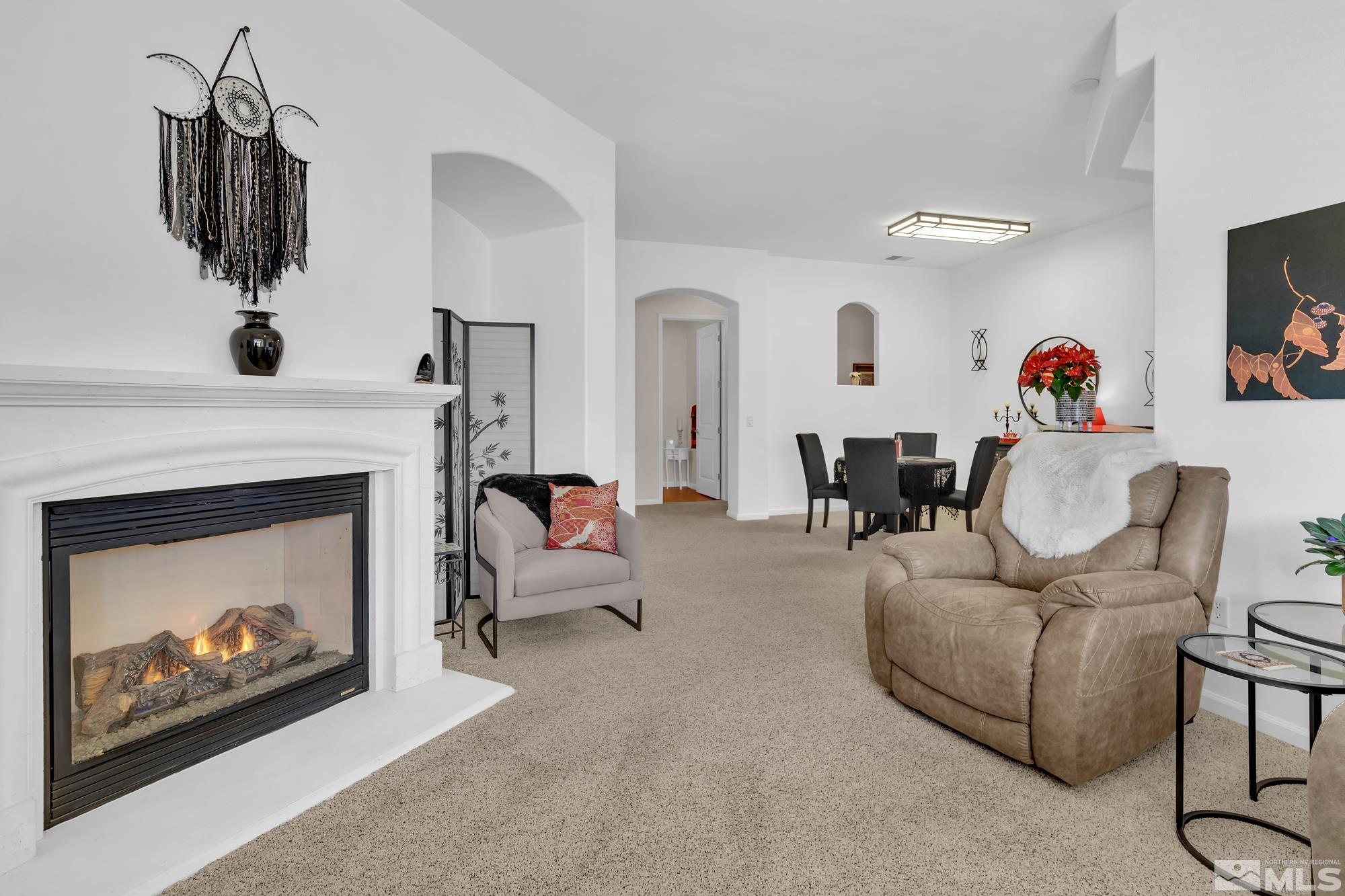 9900 Wilbur May, Unit 3902 Reno, NV 89521 - Photo 9 of 28 a living room with furniture a fireplace and a flat screen tv