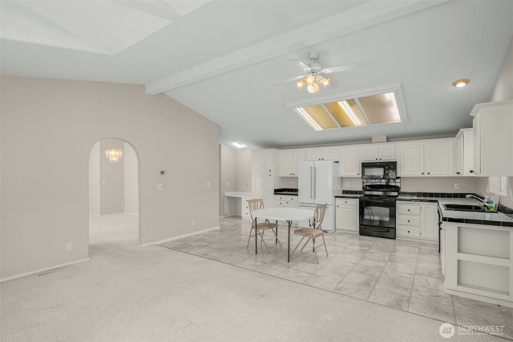 23606 Lake Drive West Bothell, WA 98021 - Photo 10 of 30 a kitchen with stainless steel appliances granite countertop a stove top oven a sink a dining table and chairs with wooden floor