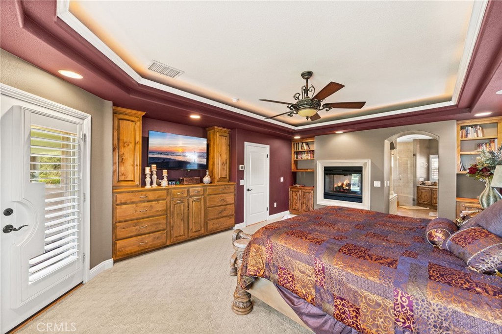 38136 Butterfly Court Yucaipa, CA 92399 - Photo 45 of 71 a spacious bedroom with a large bed and a ceiling fan
