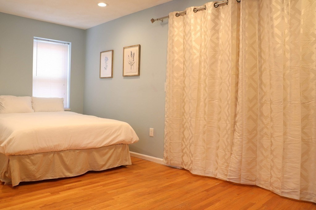 12 Regent Street, Unit 2F Cambridge, MA 02140 - Photo 28 of 29 a bedroom with a bed and a curtain with wooden floor