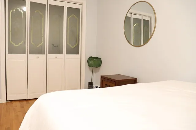 a large bed sitting in a bedroom with a large window