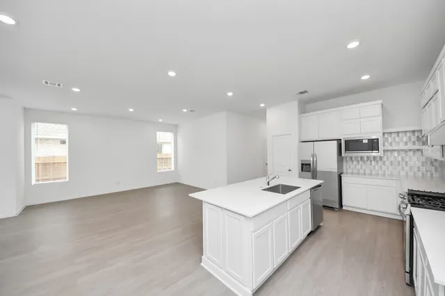 a kitchen with a sink a counter top space stainless steel appliances