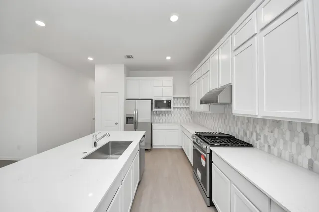 a kitchen that has a sink and a stove in it