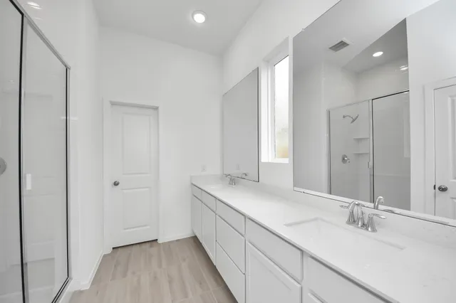 a bathroom with a sink double vanity granite tub and shower