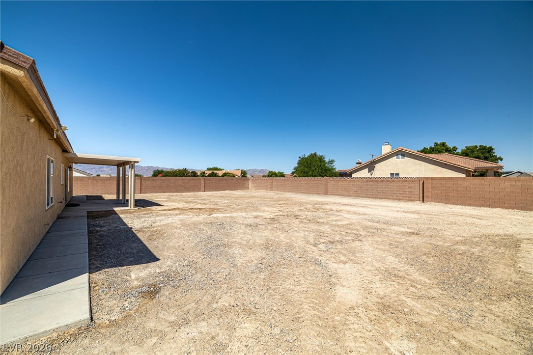 6720 Stubblefield Drive Pahrump, NV 89061 - Photo 36 of 51 A spacious backyard awaits, featuring a covered patio and a sturdy block wall.