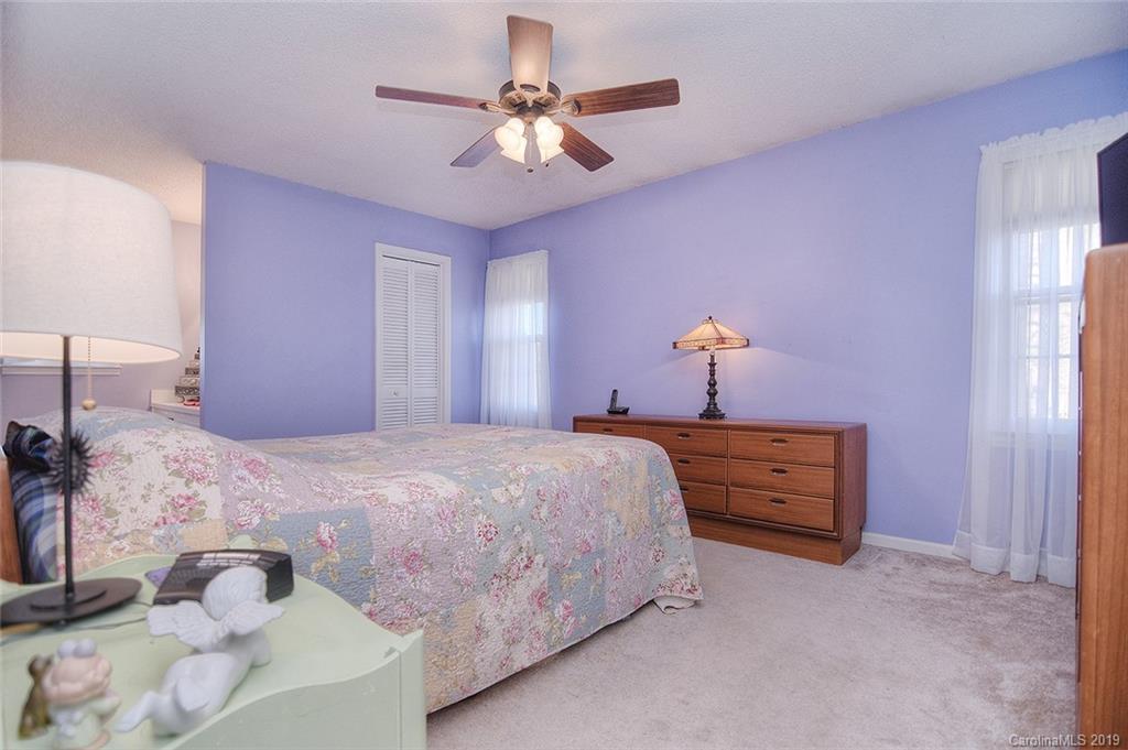 6045 Windjammer Drive Tega Cay, SC 29708 - Photo 15 of 31 a bedroom with bed and a chandelier