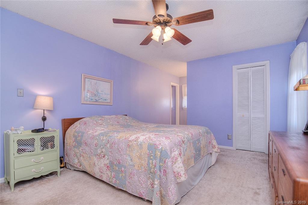 6045 Windjammer Drive Tega Cay, SC 29708 - Photo 16 of 31 a bedroom with a bed chandelier and a window
